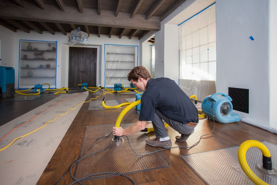 Air movers and drying equipment set up in a water damaged room