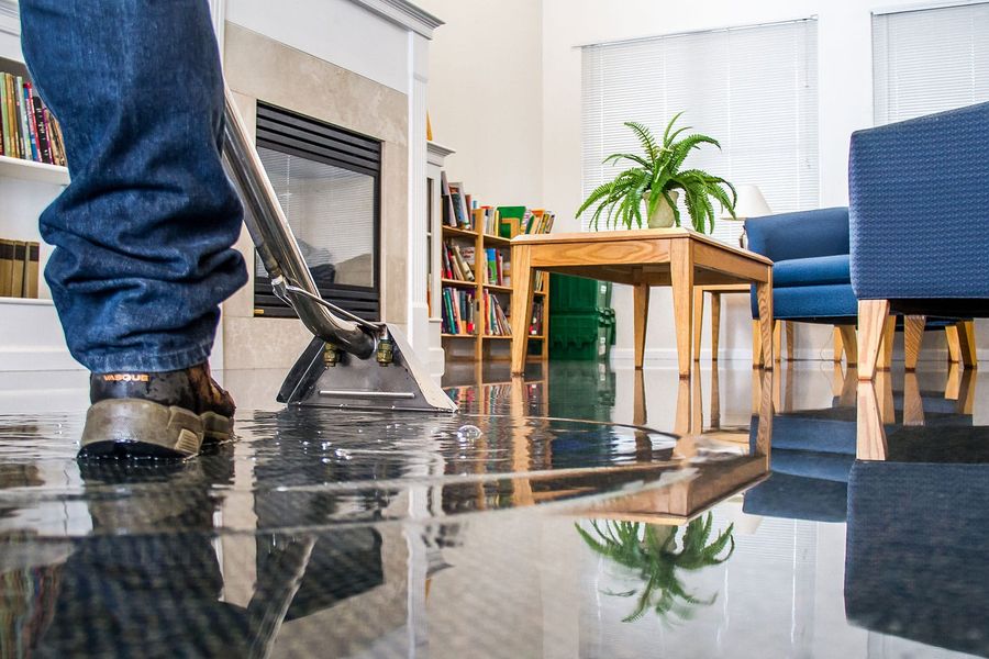 Technician extracting standing water from a flooded interior floor